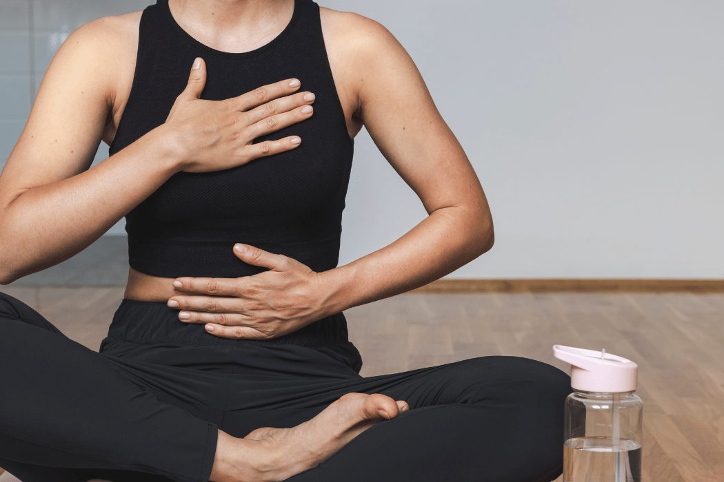 Person seated in a relaxed position using diaphragmatic breathing to practice controlled breath awareness.