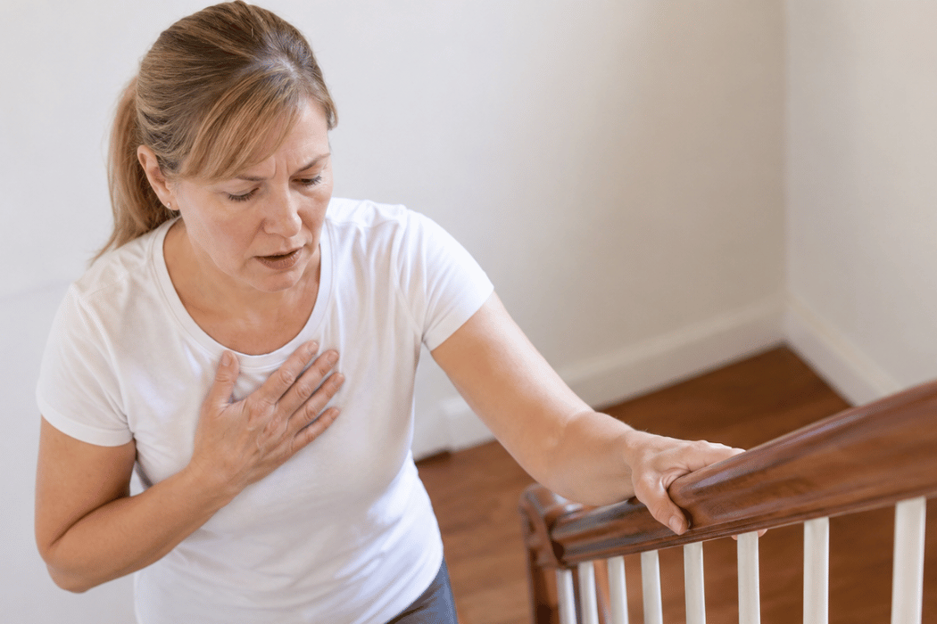 Woman pausing on the stairs after becoming winded while climbing.