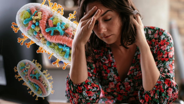 Tired woman sitting at a desk with a mitochondria illustration representing cellular energy production.